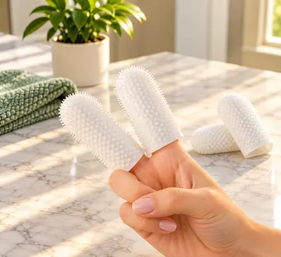 Dedos de limpieza blancos y texturados, dos puestos en una mano y otros sobre el mesón